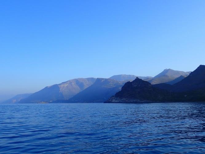 Moving again with an early start, and alternating paddle and sail... This is a few miles out of Maratea, where a morning land breeze falls out of the valleys, but between valleys there is zero wind